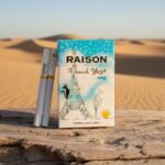 ซองบุหรี่ Raison French Yogo และมวนบุหรี่ วางบนขอนไม้ท่ามกลางทะเลทรายสีทอง แสงอาทิตย์ยามเย็น