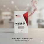 ซองบุหรี่ Vess Red แบบซองแข็ง วางบนพื้นผิวเรียบหรู พร้อมควันสีแดงจางๆ สื่อถึงความนุ่มและมีระดับ