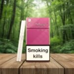 ซองบุหรี่ Davidoff Magenta สีชมพูหรูหรา วางคู่กับมวนบุหรี่แบบ Super Slims บนโต๊ะไม้ในบรรยากาศป่าธรรมชาติ