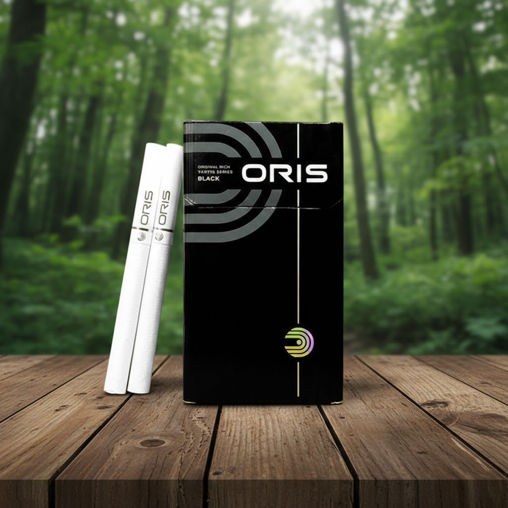 ซองบุหรี่ Oris Intense Black วางบนโต๊ะไม้ในบรรยากาศป่าเขียวขจี แสดงดีไซน์หรูหราสีดำสลับเงิน