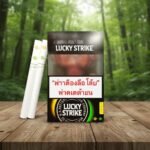 บุหรี่ Lucky Strike Double Click Yellow-Green แบบซองและมวน วางบนโต๊ะไม้ฉากหลังป่าเขียว