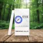 บุหรี่ ESSE Change 1mg Limited Edition แบบซองและมวน วางบนโต๊ะไม้ฉากหลังป่า