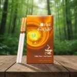 ซองบุหรี่ ESSE Ice Cafe สีน้ำตาลทองลายเกลียว พร้อมมวนบุหรี่แบบ Slim วางบนโต๊ะไม้ในบรรยากาศป่าเขียวขจี