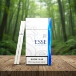 ซองบุหรี่ ESSE Lights Super Slim และมวนบุหรี่แบบสลิม วางบนโต๊ะไม้พื้นหลังป่าธรรมชาติ
