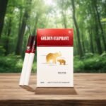 ซองบุหรี่ Golden Elephant และบุหรี่ 2 มวน วางบนโต๊ะไม้ ท่ามกลางบรรยากาศป่าสีเขียว