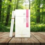 ซองบุหรี่ ESSE Classic สีขาวมวนสลิม วางบนโต๊ะไม้ฉากหลังเป็นป่าธรรมชาติ