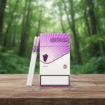 บุหรี่ Oris Grape ซองสีม่วงสลับขาวลายองุ่น วางคู่กับมวนบุหรี่ซุปเปอร์สลิมบนโต๊ะไม้ ฉากหลังเป็นป่าไม้สีเขียว