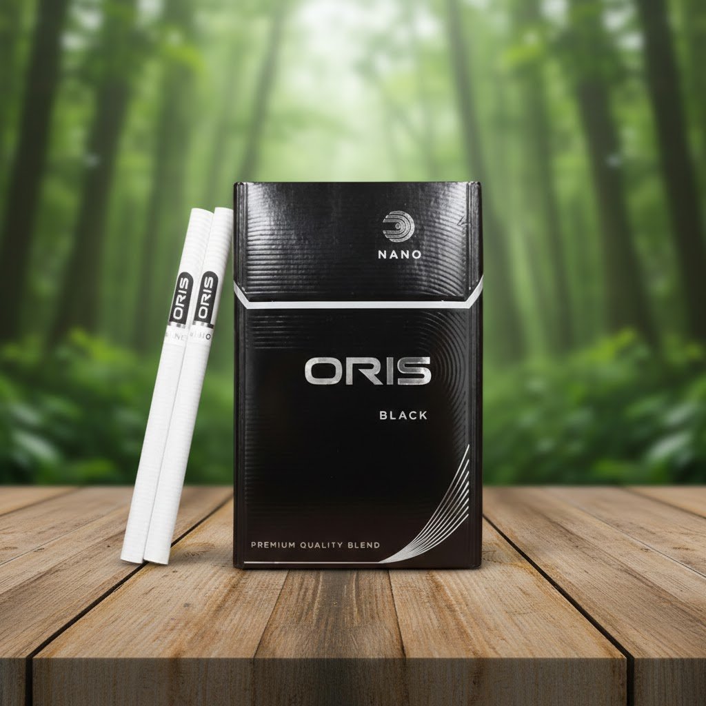 บุหรี่ Oris Nano Black ซองสีดำดีไซน์เรียบหรู วางคู่กับมวนบุหรี่นาโนสลิมบนโต๊ะไม้ ฉากหลังเป็นป่าไม้