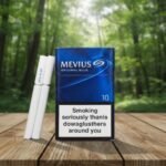 บุหรี่ Mevius Original Blue ซองสีน้ำเงินเข้มวางคู่กับมวนบุหรี่บนโต๊ะไม้ พื้นหลังป่าธรรมชาติ